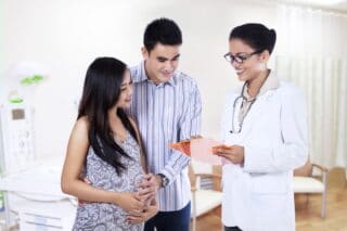 Doctor providing prenatal care to a pregnant couple