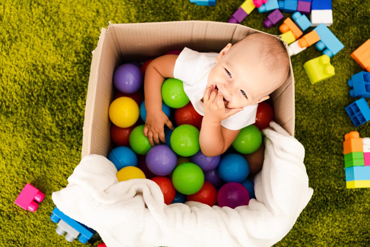 baby in box filled with balls