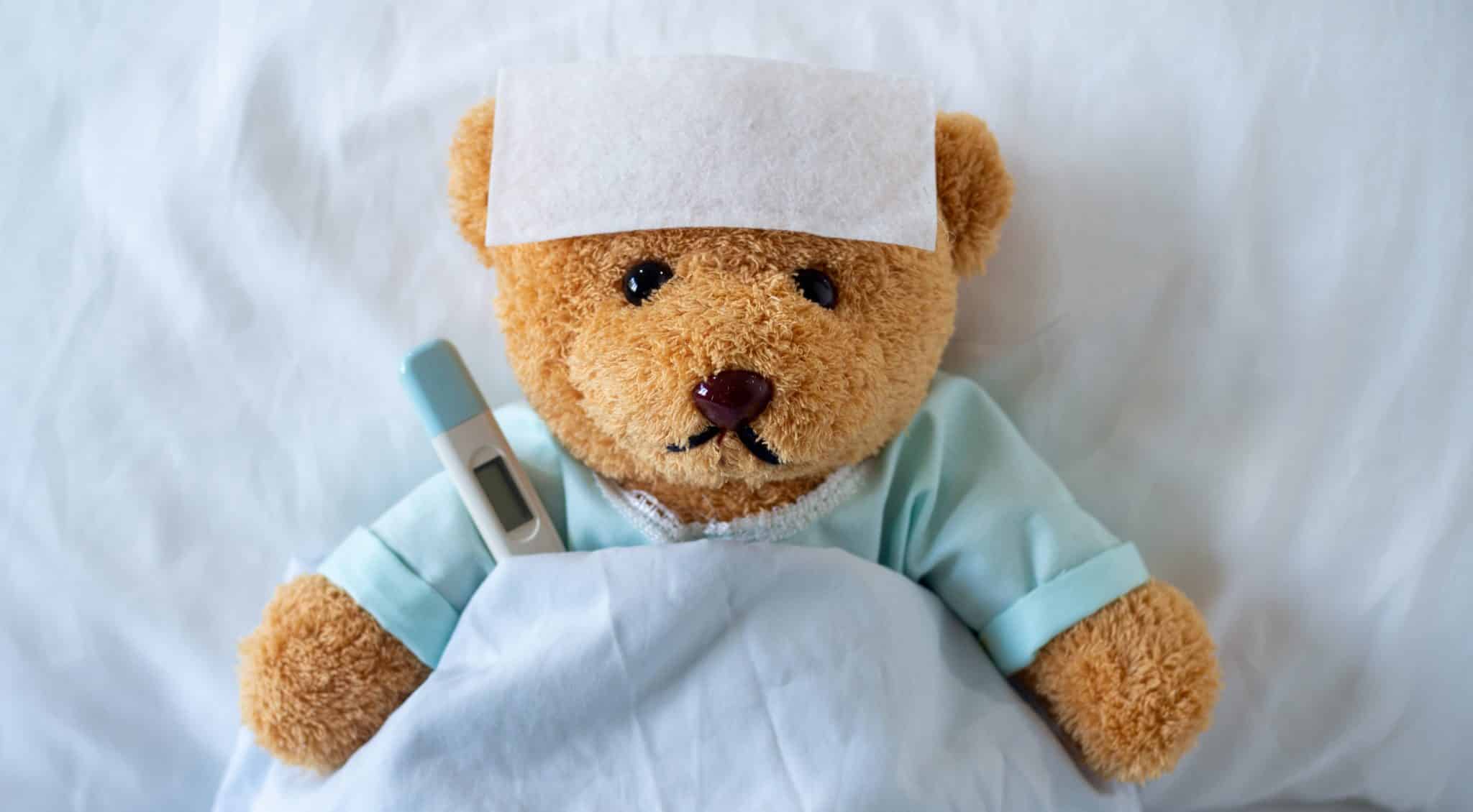 Side effects are expected. Teddy bear with cold pack and thermometer